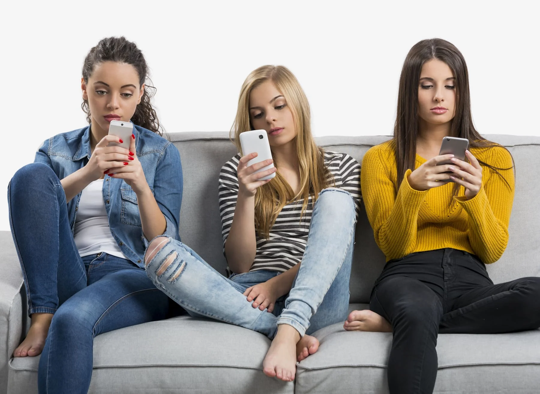3 teens sitting on the couch on their phones looking bored