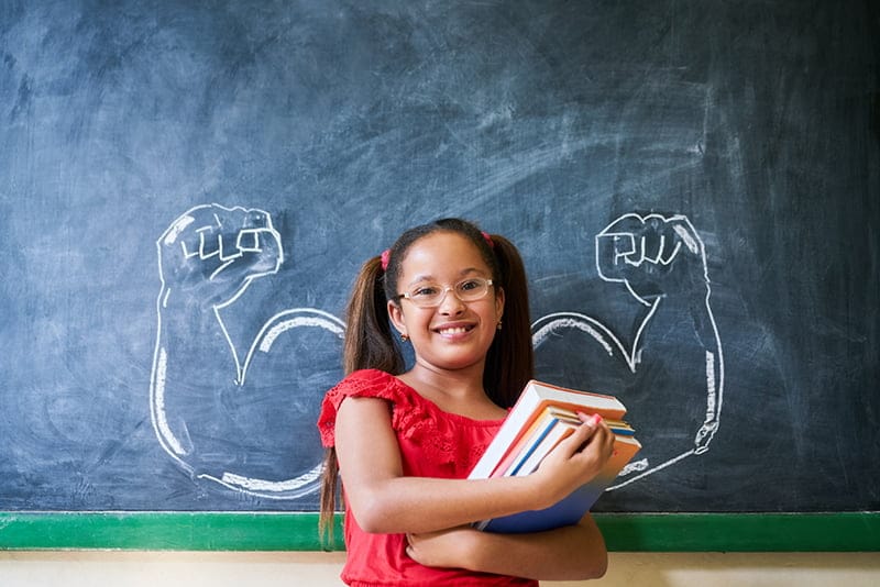 fall_karate_offer Girl standing next to chalk board with arms and muscles drawn behind her