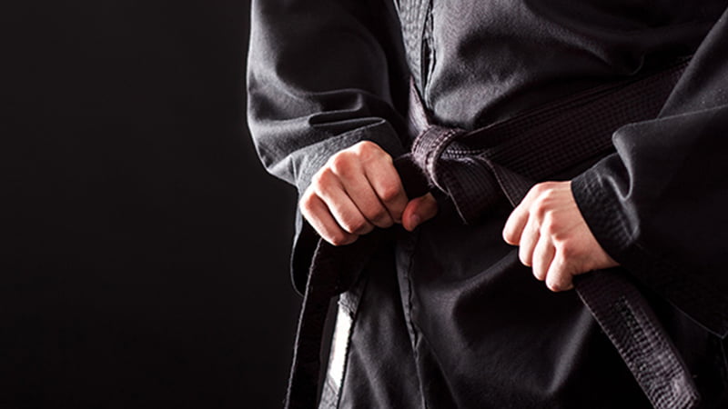 black belt member tying belt